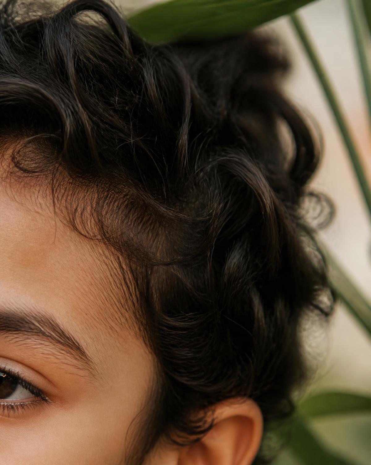 Wavy dark hair and hairline of a Middle Eastern child